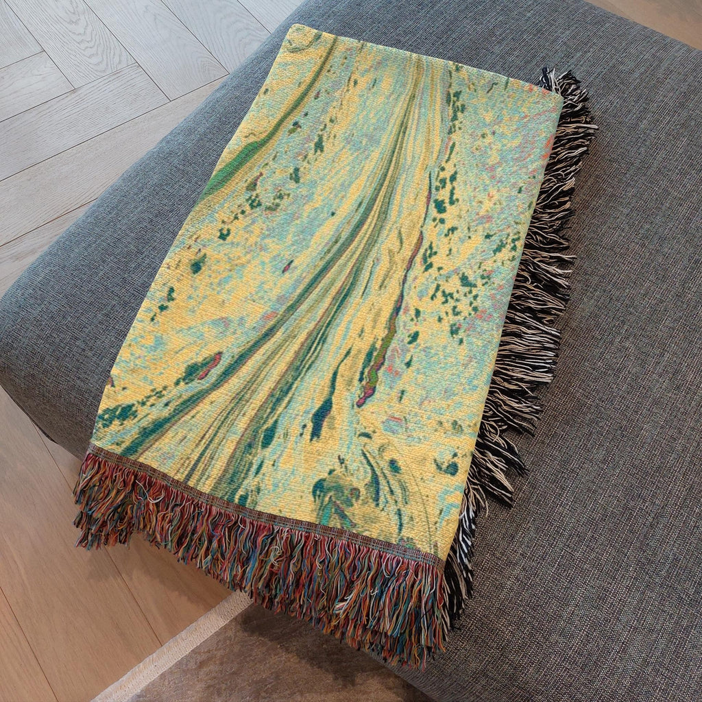 Kök Stüdyo woven cotton throw blanket with abstract pastel marbling art in yellow, green, and blue hues.