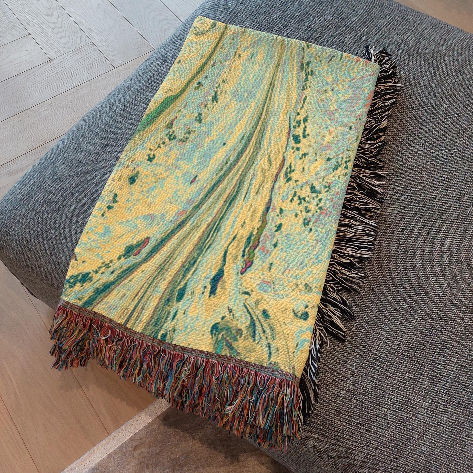 Kök Stüdyo woven cotton throw blanket with abstract pastel marbling art in yellow, green, and blue hues.
