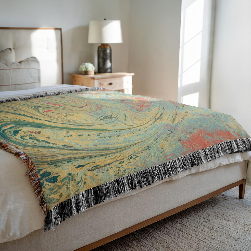 Kök Stüdyo woven cotton throw blanket with abstract pastel marbling pattern in yellow, teal, and coral.