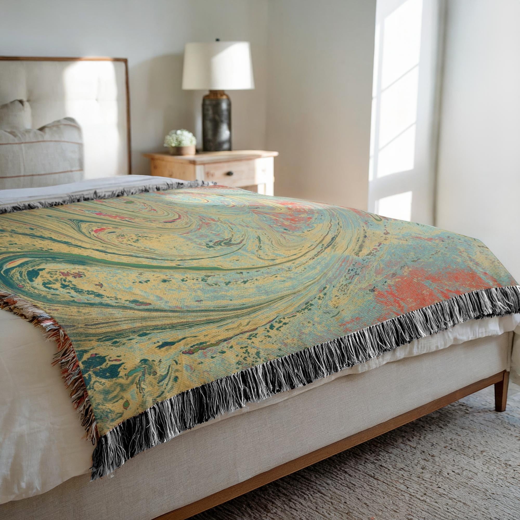 Kök Stüdyo woven cotton throw blanket with abstract pastel marbling pattern in yellow, teal, and coral.