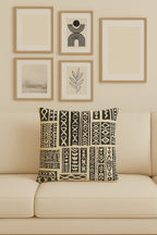 Kök Stüdyo African mud cloth inspired woven throw pillow with black and cream geometric patterns and tufted texture.