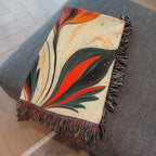 Kök Stüdyo woven throw blanket with a traditional Turkish marbling tulip design in vibrant orange, red, and dark green on a cream background.