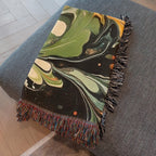 Kök Stüdyo abstract green and black marbling woven cotton throw blanket with colorful fringe.